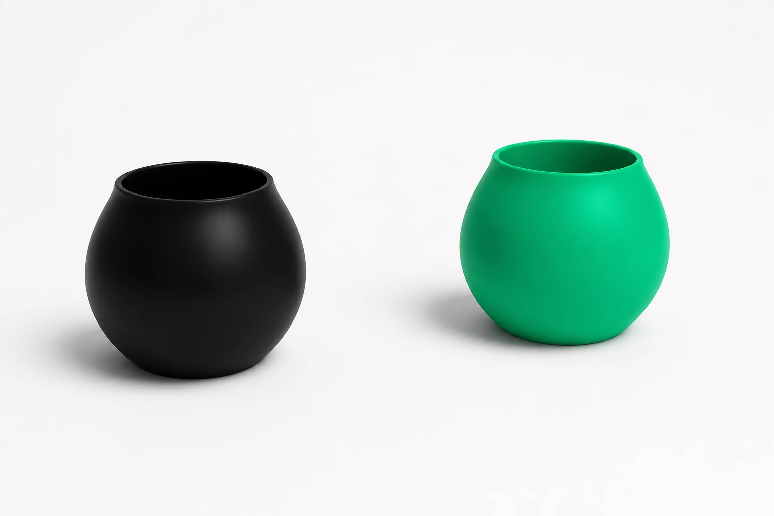 Two round bowls on a white field, one matte black and one brand green, sitting as a separated pair.